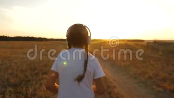 年轻女孩穿着白色T恤在日落时训练用耳机听音乐日落时做运动慢跑视频的预览图