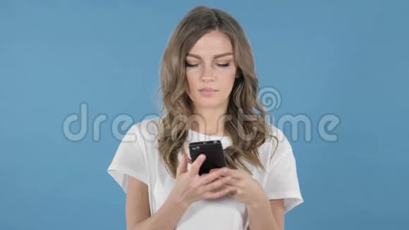 蓝底智能手机上聊天的少女视频的预览图