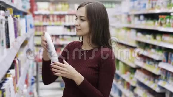 有魅力的女人在超市里拿着沐浴露闻一闻情感就像产品一样视频的预览图