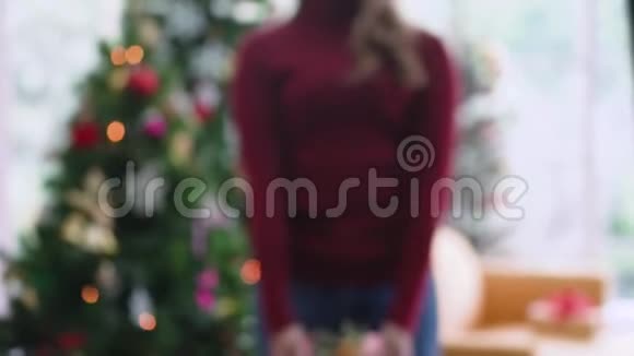 亚洲女孩带着笑脸给镜头送圣诞礼物视频的预览图
