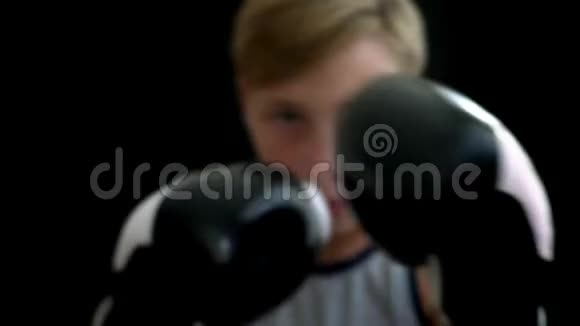 这个男孩从事拳击前景中有双手戴着黑白手套男孩脸模糊A视频的预览图