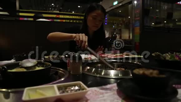 美丽的亚洲女人在中餐馆做烧烤烤肉视频的预览图