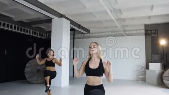 运动和健康的生活方式一群穿着黑色紧身衣的运动女孩在健身室里进行热身运动视频的预览图