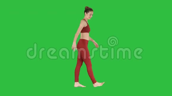 女性女运动员在绿色屏幕上行走时伸展手臂色度键视频的预览图