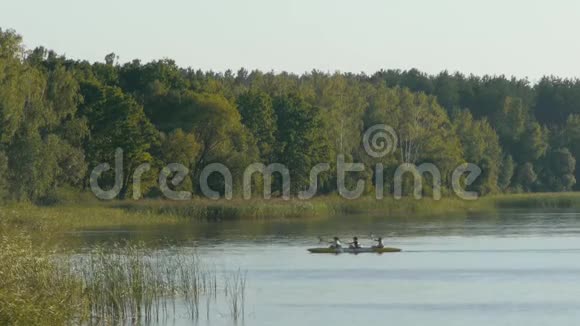 日落时分三个人坐着皮艇在湖边游泳视频的预览图