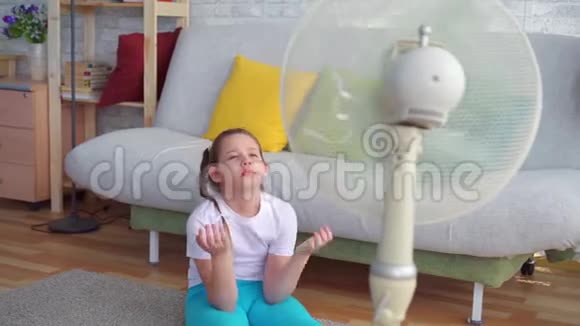 一个年轻女孩挨着一个受炎热天气影响的粉丝视频的预览图