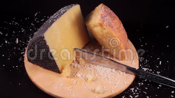 磨碎的山核桃奶酪在木切割板上落在一片撒丁山核桃奶酪上的缓慢运动视频的预览图