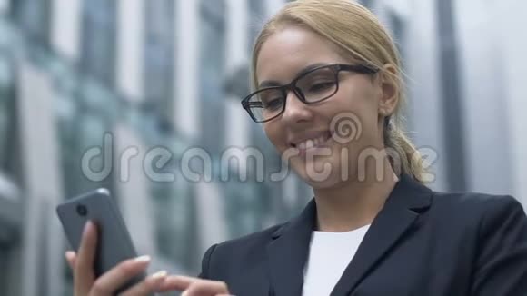 商务女性在智能手机上查看现代商务应用程序中的新闻和电子邮件视频的预览图