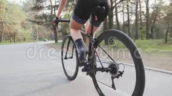 三项运动员在城市公园骑自行车训练脚踏技术腿部肌肉收拢铁人三项的概念慢动作视频的预览图