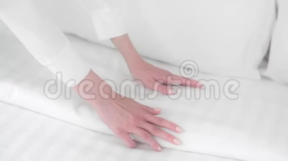 女人整理床铺女佣整理毯子整理床铺新床单床单洁净室第422号总部视频的预览图