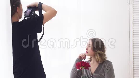 专业摄影棚摄影师特写手里拿着大红花拍模特媒体视频的预览图