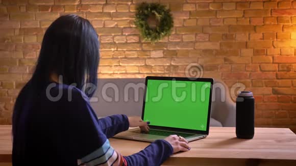 室内绿色彩色屏幕的年轻迷人女性笔记本电脑的特写镜头视频的预览图