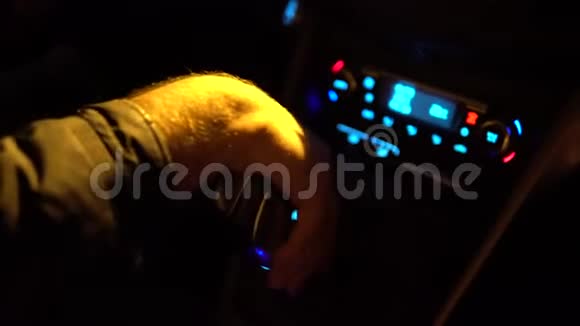 司机控制汽车并握住换档器或齿轮旋钮齿轮棒在夜间阴影道路灯关闭视频的预览图