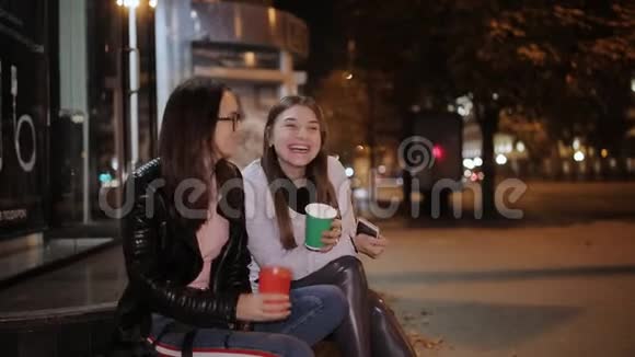 两个女孩晚上坐在路边聊天喝咖啡视频的预览图