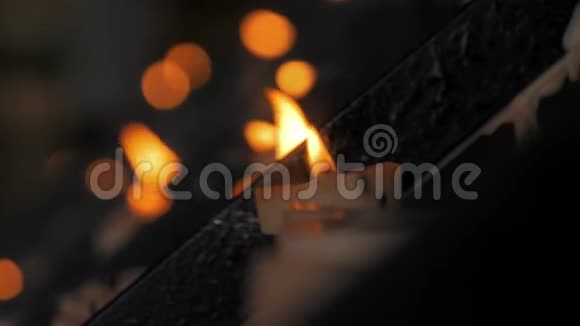 天主教堂里许多燃烧着的蜡烛的特写镜头背景是黑暗的光视频的预览图