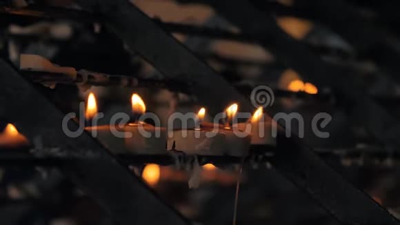 天主教堂里许多燃烧着的蜡烛的特写镜头背景是黑暗的光视频的预览图