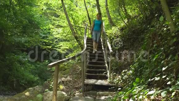 徒步旅行美丽的女人带着背包走下楼梯在丛林野生自然公园在山上旅游观光视频的预览图