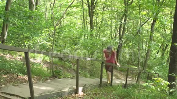 徒步旅行两名游客在楼梯上相遇相约男子在丛林野生自然公园迎接年轻女子视频的预览图