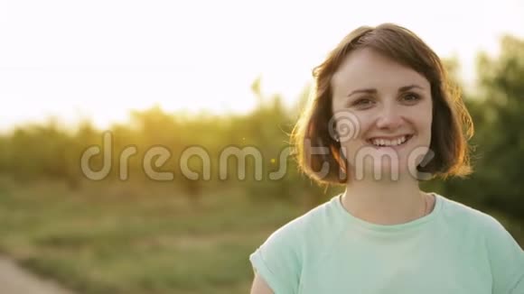 年轻积极的白种人女孩享受生活和在镜头前笑在西班牙农村公路通过农村小麦视频的预览图