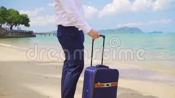 商人的双腿带着一个手提箱沿着美丽的大海的海岸行走自由职业概念期待已久的休闲视频的预览图
