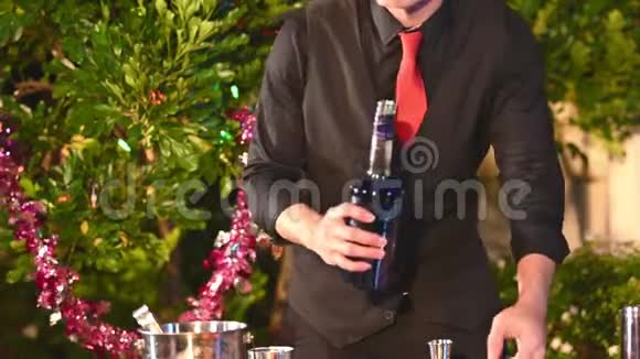漂亮的亚洲男调酒师穿着黑色正式西装搭配红领结兼职做鸡尾酒艺人视频的预览图