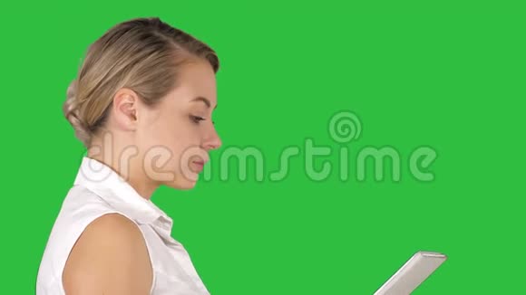 单个女孩步行和观看媒体内容在线在平板上的绿色屏幕Chroma键视频的预览图