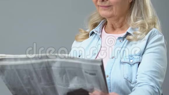 女性养老金领取者通过放大镜阅读报纸视力差视频的预览图
