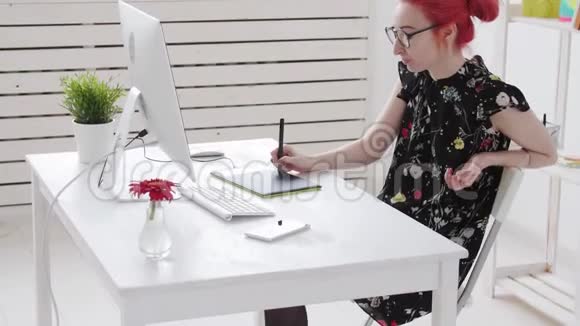 有彩色头发的照片编辑器用电脑上的图形平板电脑和烟卷视频的预览图