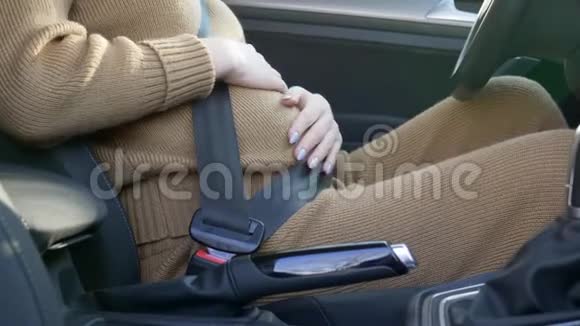 孕妇司机在方向盘后关心未来的母亲戴着安全带抚摸着肚子未来的婴儿坐在旁边视频的预览图