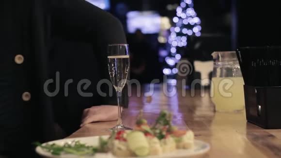 酒保手拿着一杯香槟在酒吧柜台模糊的背景下递给一个男人视频的预览图