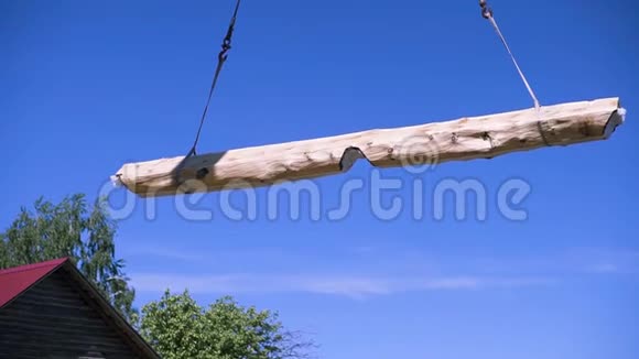 起重机在蓝天背景上举起木梁剪辑农村地区新生态友好型住宅的要素木工视频的预览图