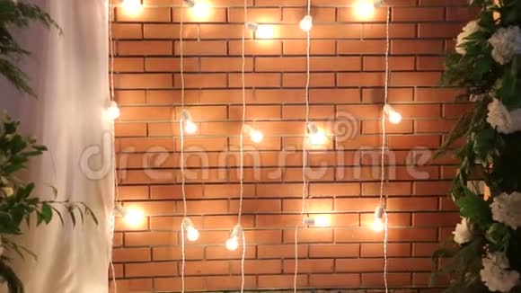 靠近砖墙的灯泡灯光装饰以供庆祝视频的预览图