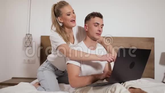 夫妻在床上用笔记本电脑视频的预览图