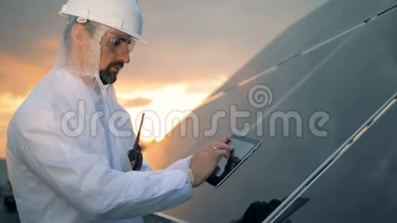人在检查太阳能电池板时使用平板电脑关闭视频的预览图