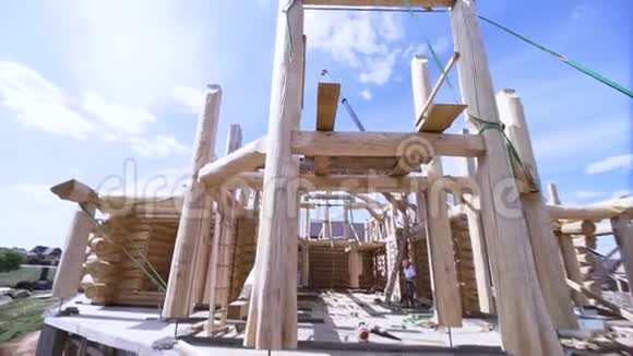 新房子正在建造中一个木匠站在框架内的蓝色多云的天空背景剪辑基本观点视频的预览图