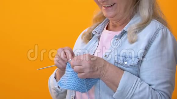 白发苍苍的祖母在黄色背景下编织手艺爱好退休视频的预览图