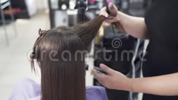 特写一个较短的拍摄程序角蛋白头发矫直理发师给顾客理发视频的预览图
