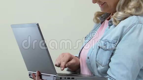微笑成熟的女性在笔记本电脑键盘现代技术小工具视频的预览图