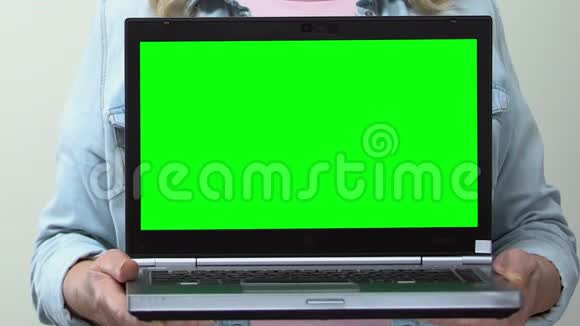 手里拿着绿色屏幕的笔记本电脑的女人信用在线购物应用程序视频的预览图