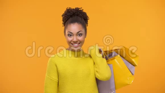 可爱的非裔美国女士拿着信用推车和购物袋购物狂视频的预览图