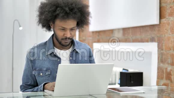 厌倦了在笔记本电脑上工作的非洲男人视频的预览图