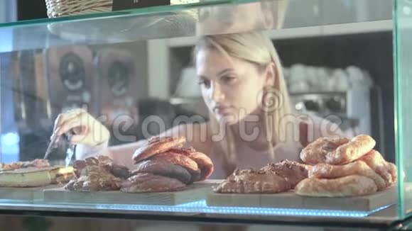 美丽的年轻女卖家在糖果店工作提供新鲜糕点的特写镜头视频的预览图