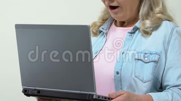 令人惊讶的是女人手里拿着笔记本电脑在网上看视频视频的预览图