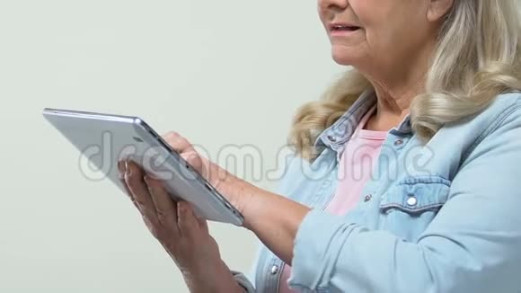体贴的祖母滚动平板照片网络冲浪应用程序社交网络视频的预览图