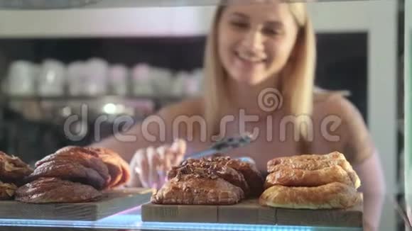 美丽的年轻女卖家在糖果店工作提供新鲜糕点的特写镜头视频的预览图