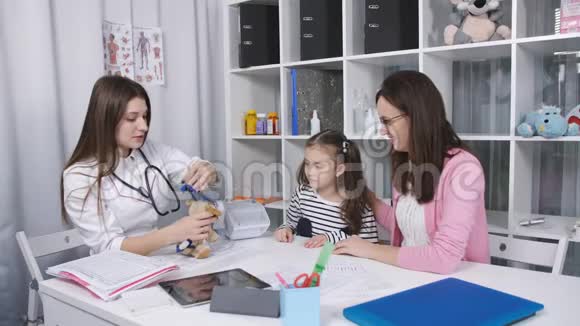 医生给小女孩看如何雾化毛绒玩具医生在吸入前安慰小女孩视频的预览图