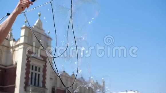 夏天在克拉科夫广场上快乐的肥皂泡被笑着的孩子们抓住了视频的预览图