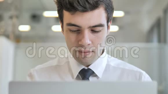 一个年轻的商人用手提电脑视频的预览图