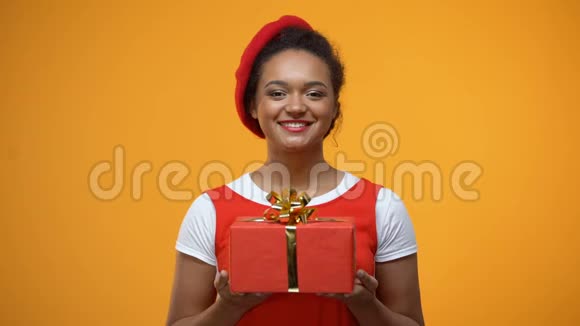 快乐的女人伸出双手展示在相机红色礼品盒中节日礼物视频的预览图