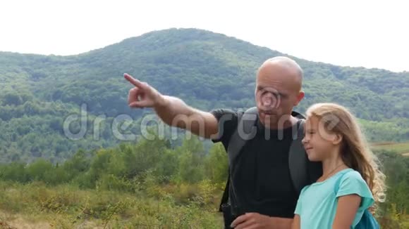 父亲带着女儿在山里眺望远方视频的预览图